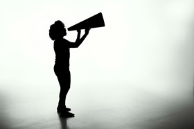 Silhouette of a person holding a magaphone
