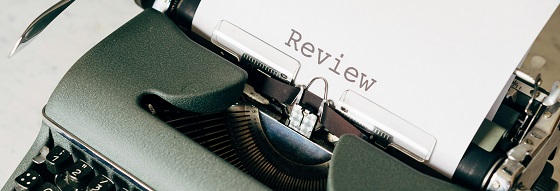 Close up picture of an old-fashioned typewriter, with a white piece of paper in it with the word review typed onto it 